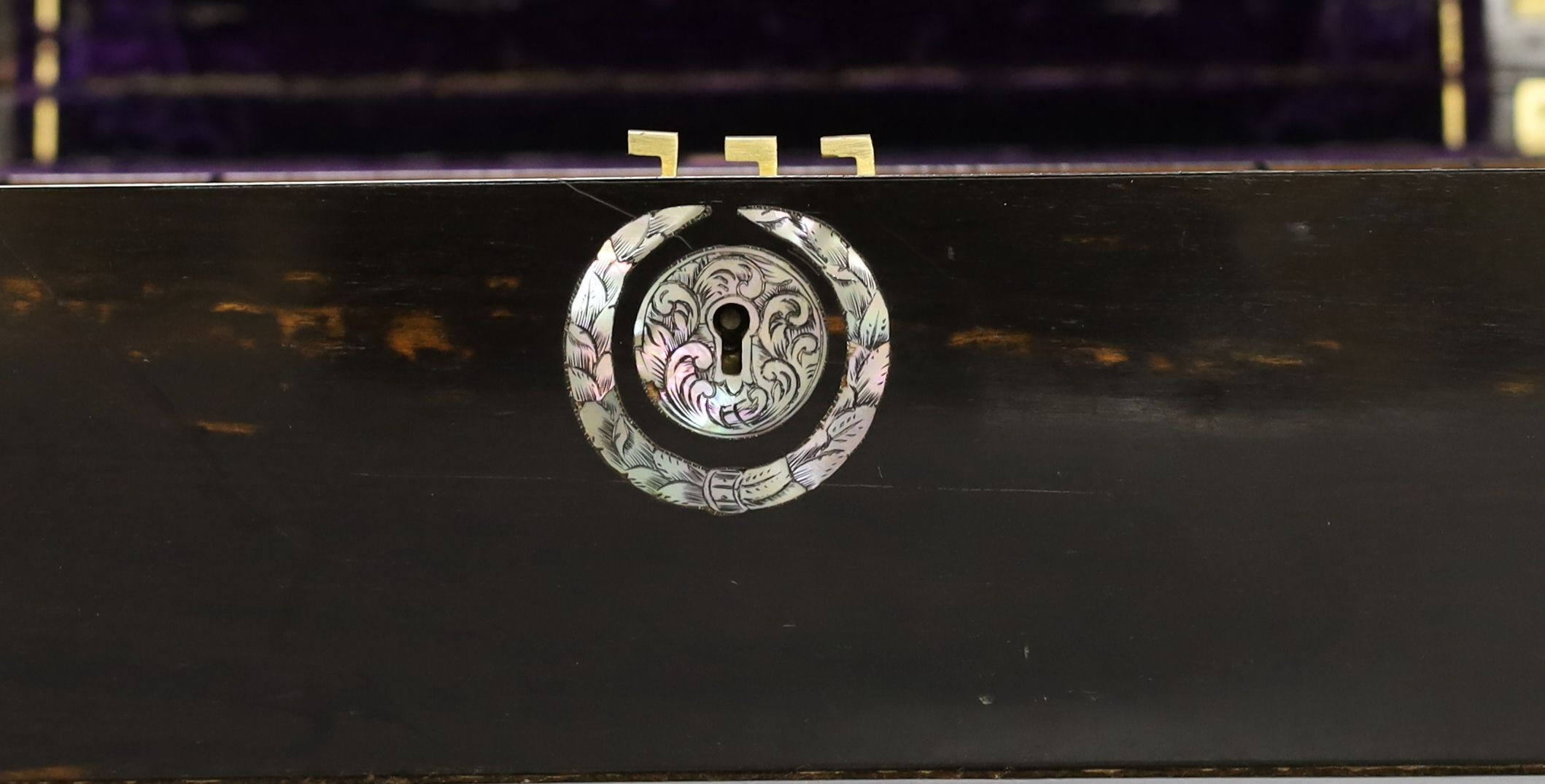 A 19th century coromandel wood writing slope with mother-of-pearl cartouche and original purple tooled velvet interior, 38 cms wide by 25 cms deep.